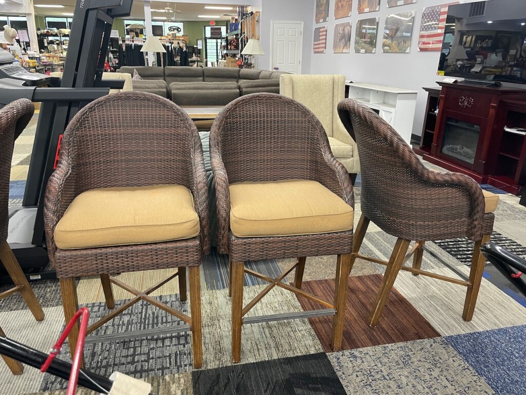 Tall brown wicker chairs with gold seat cushions